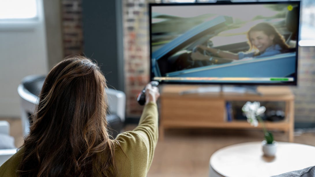 Woman switching channels on her television